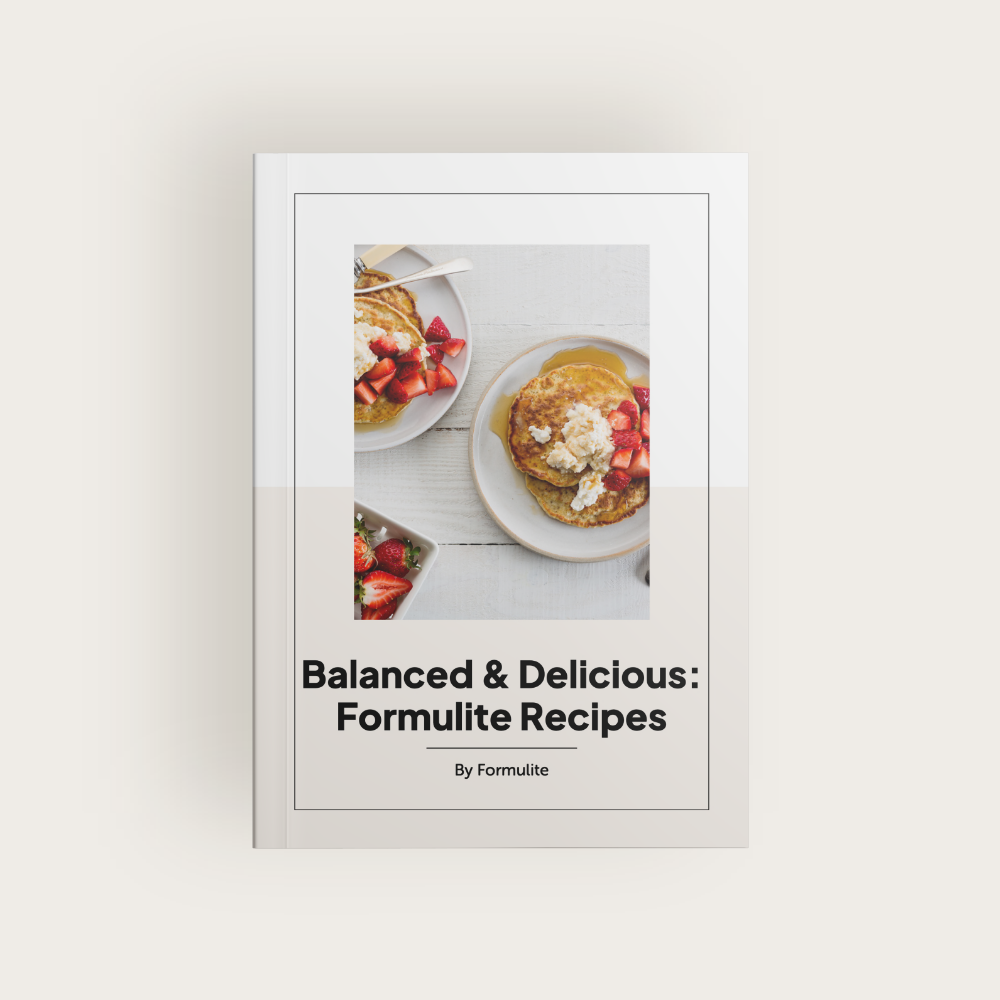 Book cover: "Balanced & Delicious: Formulite Recipes." Photo shows pancakes with strawberries and cream. By Formulite.