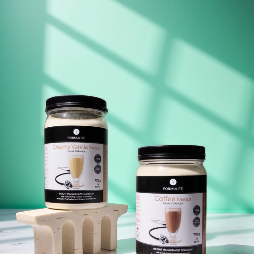 Two Formulite shake formula jars, vanilla and coffee flavors, on a small arched stand against a teal background.